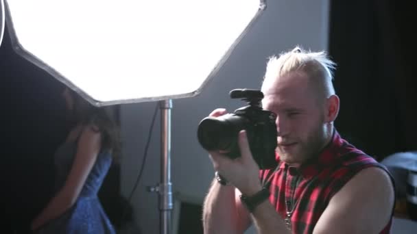 Człowiek fotograf robi zdjęcia z profesjonalnym aparatem, w studiu — Wideo stockowe