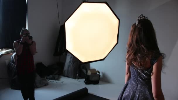 Fotografiando a una modelo, morena, en un vestido gris brillante, en el estudio — Vídeos de Stock