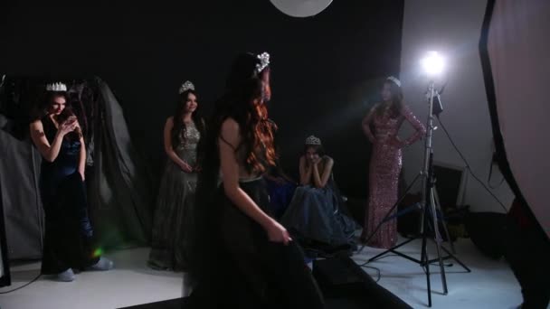 Брюнетка девушка, в темном прозрачном платье с обнаженной спиной, позирует в студии — стоковое видео