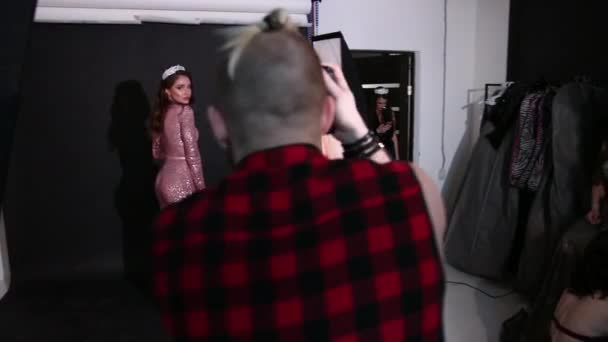 Φωτογράφος φωτογραφίες μοντέλο, καστανά μαλλιά, σε ένα ροζ φόρεμα, στο στούντιο — Αρχείο Βίντεο
