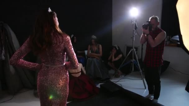 Gadis berambut coklat dengan gaun merah muda mengkilap, dengan mahkota, pemotretan di Studio — Stok Video