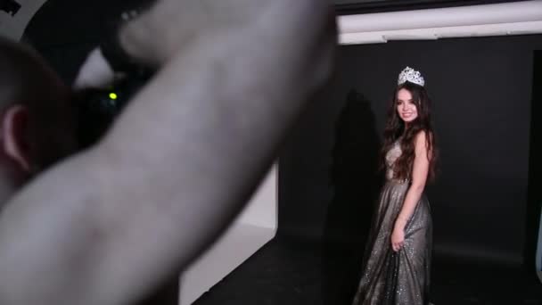 Photographer photographs model, brunette, in a shiny dress, in the Studio — Stock Video