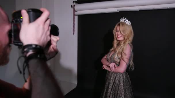 Fotograf fotograferar en tjej modell, Blond, i en vacker klänning, i studion — Stockvideo