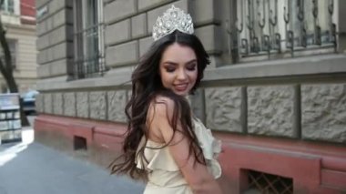 hafif bir elbise kız model esmer, bir taç ile, sokakta photoshoot