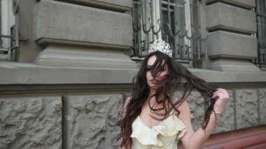 hafif bir elbise kız model esmer, bir taç ile, sokakta photoshoot