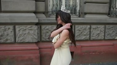 hafif bir elbise kız model esmer, bir taç ile, sokakta photoshoot