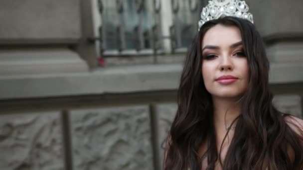 Girl model brunette in a light dress, with a crown, photoshoot on the street — Stock Video