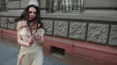 hafif bir elbise kız model esmer, bir taç ile, sokakta photoshoot