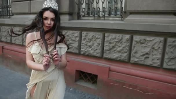 Mädchen Modell Brünette in einem hellen Kleid, mit einer Krone, Fotoshooting auf der Straße — Stockvideo