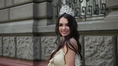 hafif bir elbise kız model esmer, bir taç ile, sokakta photoshoot