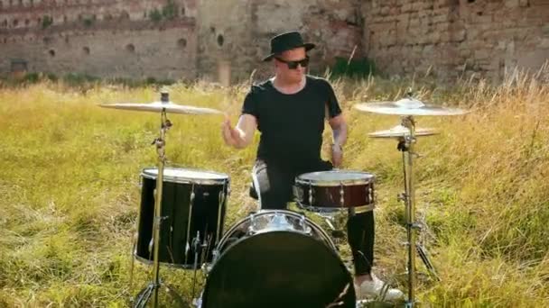 Baterista músico vestido com roupas pretas, chapéu, tocando bateria e pratos — Vídeo de Stock