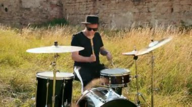 siyah şapka giymiş müzisyen davulcu, davul seti ve ziller, sokakta oynuyor