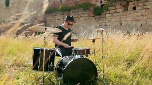 Musician drummer dressed in black hat, playing drum set and cymbals, on street — Stock Video