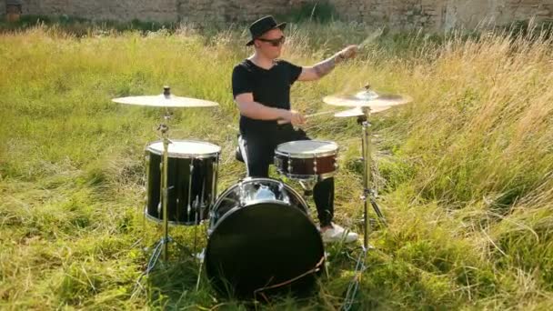 Baterista músico vestido con ropa negra, sombrero, tocando el tambor y platillos — Vídeos de Stock