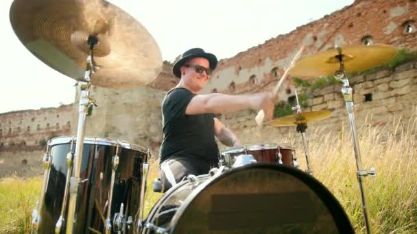 Musiker trummisen klädd i svart hatt, Spela trumset och cymbaler, på gatan — Stockvideo