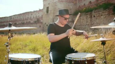 siyah şapka giymiş müzisyen davulcu, davul seti ve ziller, sokakta oynuyor