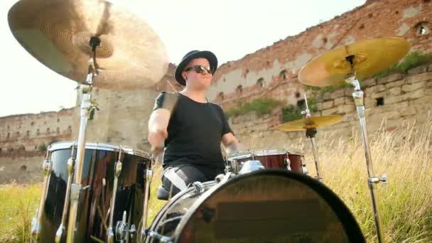 音乐家鼓手身着黑色衣服，帽子，演奏鼓套和圆环 — 图库视频影像