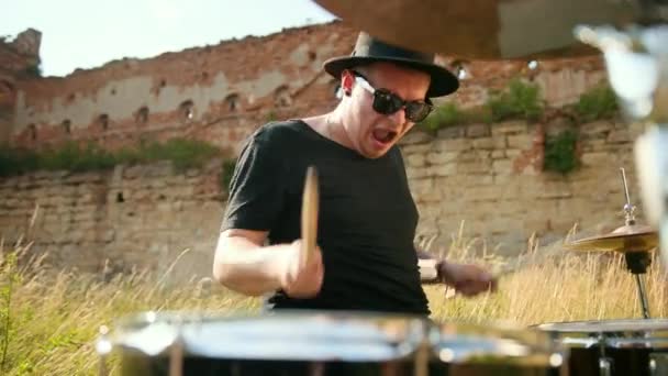 Musicien batteur vêtu d'un chapeau noir, jouant du tambour et des cymbales, dans la rue — Video