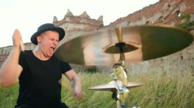 siyah şapka giymiş müzisyen davulcu, davul seti ve ziller, sokakta oynuyor