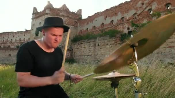 Bubeník, hrající na bicí souprava a činely, na ulici nedaleko zničené budovy — Stock video