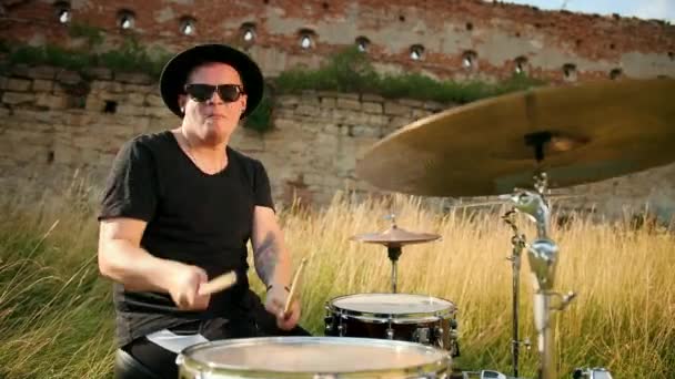Baterista músico vestido com roupas pretas, chapéu, tocando bateria e pratos — Vídeo de Stock