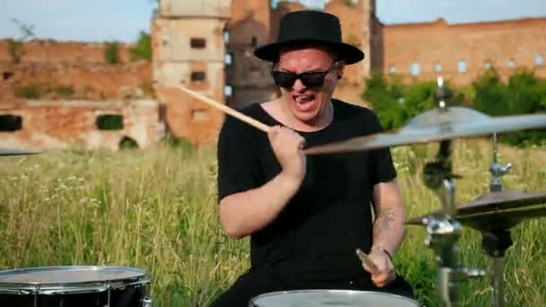 Baterista músico vestido con ropa negra, sombrero, tocando el tambor y platillos — Vídeo de stock