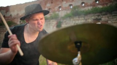 Davulcu ıslak davul çalıyor ve su yavaş çekimde sıçrıyor.