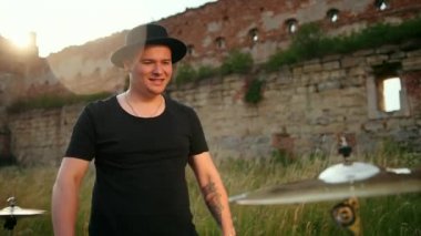 Davulcu ıslak davul çalıyor ve su yavaş çekimde sıçrıyor.