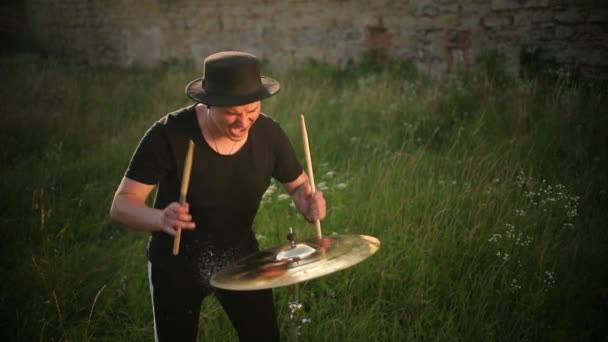 Барабанщик стучит по мокрым барабанам и брызгам воды в замедленной съемке — стоковое видео