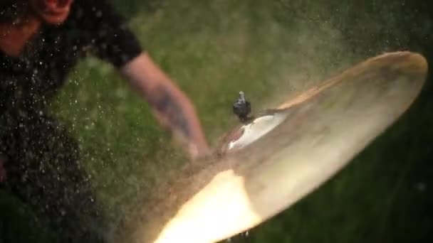 Drummer hitting on wet drum cymbal, and the water splashing in slow motion — Stock Video