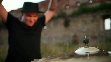 Davulcu ıslak davul çalıyor ve su yavaş çekimde sıçrıyor.
