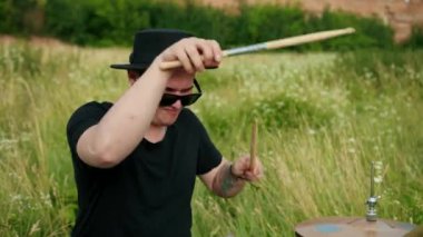 müzisyen davulcu siyah giysiler, şapka giymiş, davul seti ve ziller çalma