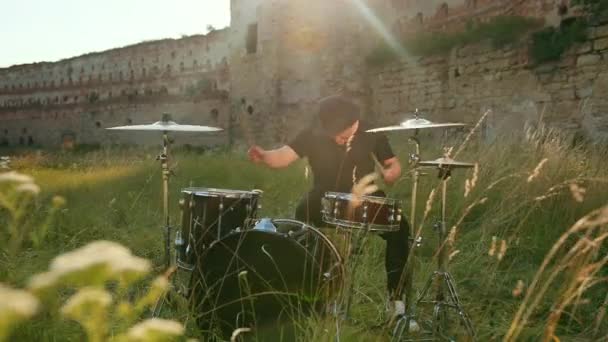 Musiker trummisen klädd i svarta kläder, mössa, Spela trumset och cymbaler — Stockvideo