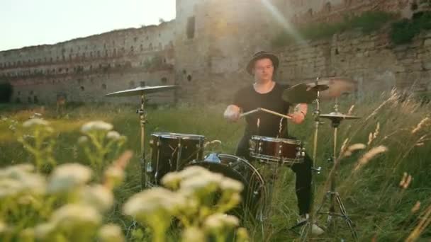 Musician drummer dressed in black hat, playing drum set and cymbals, on street — Stock Video