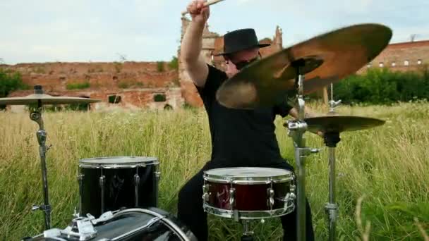 Musiker trummisen klädd i svart hatt, Spela trumset och cymbaler, på gatan — Stockvideo