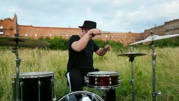 Batterista musicista vestito di cappello nero, suonando batteria e piatti, in strada — Video Stock