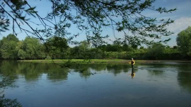 Homme pêcheur tenant une canne à pêche, lance un flotteur, pêche dans la rivière — Video