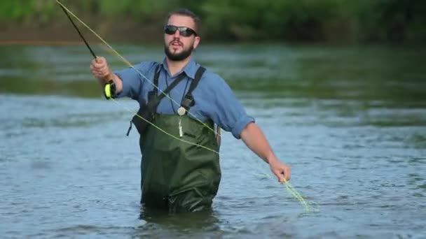 Férfi Halász kezében egy Horgászbottal, dob egy úszó, a halászat a folyón — Stock videók