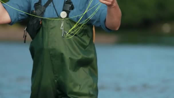 Pescador hombre sosteniendo una caña de pescar, lanza una carroza, pesca en el río — Vídeos de Stock