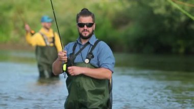 Balıkçılık, nehirde balık tutmak, suda duran iki adam, küçük bir akıntı