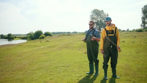 Twee mannen visser, het houden van een hengel en float, op straat — Stockvideo