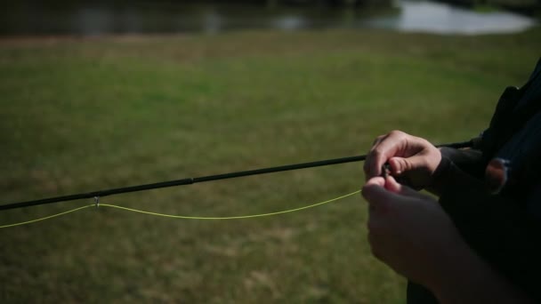 Mann fischt, angeln, Angelrute in der Hand, Köder spannen, Spinnrolle — Stockvideo