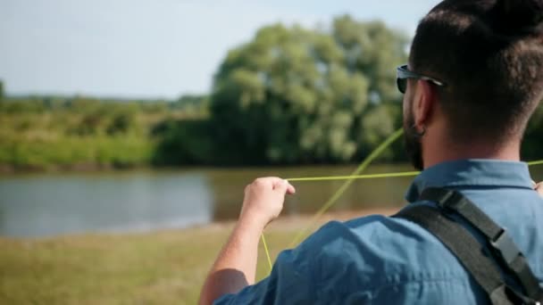男子渔夫，钓鱼，拿着钓鱼竿，串饵，纺卷 — 图库视频影像