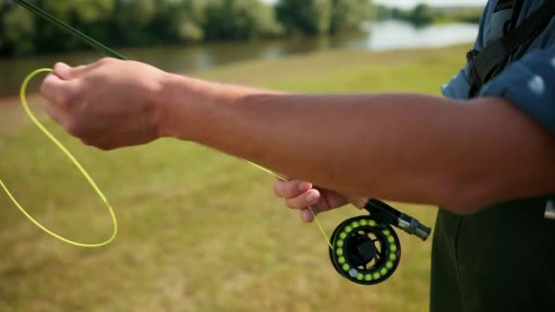 Man fisherman, fishing, holding a fishing rod, stringing bait, spinning reel — Stock Video