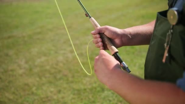 Man fiskare, fiske, innehar ett fiskespö, besträngnings bete, spinning Reel — Stockvideo