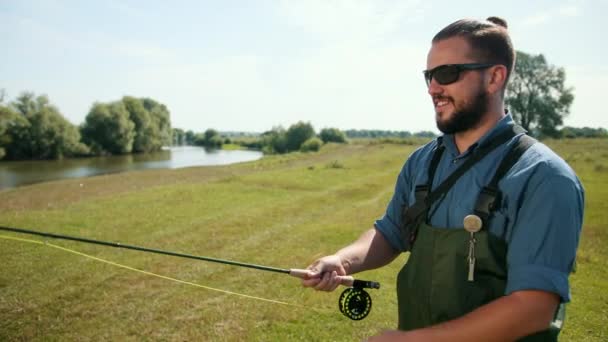 Uomo pescatore, pesca, tenendo una canna da pesca, corda esca, bobina di filatura — Video Stock