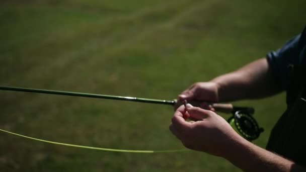 Man fiskare, fiske, innehar ett fiskespö, besträngnings bete, spinning Reel — Stockvideo