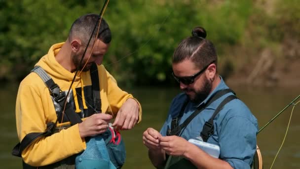Δύο άντρες ψαρά μελαχρινές με μούσι που κρατά καλάμια ψαρέματος στα χέρια τους — Αρχείο Βίντεο