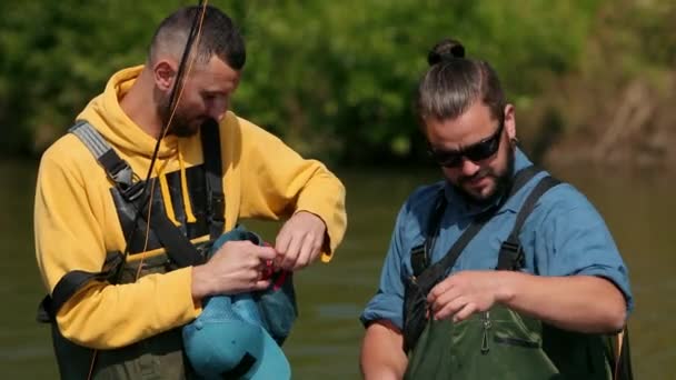 Dois homens pescador morenas com uma barba segurando varas de pesca em suas mãos — Vídeo de Stock