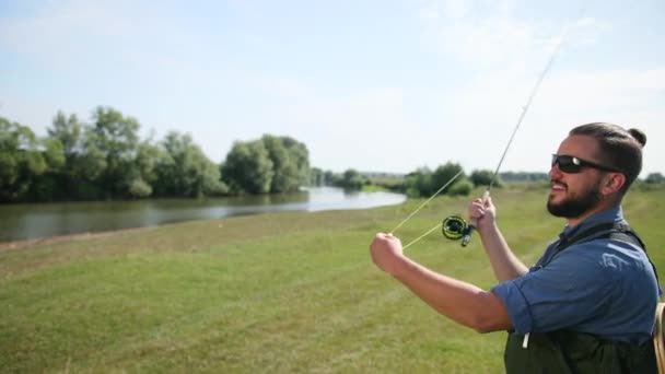 Hombre pescador, pesca, sosteniendo una caña de pescar, encadenando cebo, carrete giratorio — Vídeos de Stock